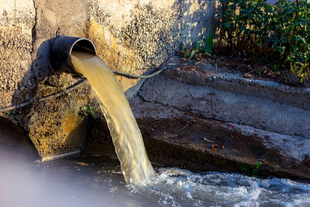 A sewage pipe pumps dirty water into a river